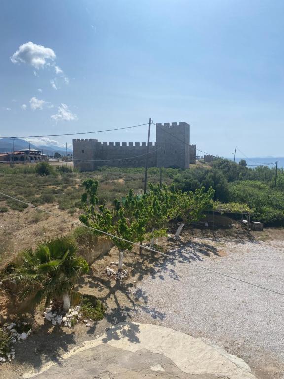 a castle on a hill with a palm tree at Artemis Hotel-MeRaki Restaurant in Frangokastello