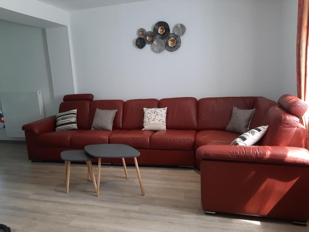 ein Wohnzimmer mit einem roten Sofa und einem Tisch in der Unterkunft Le sommet du Condroz in Ciney