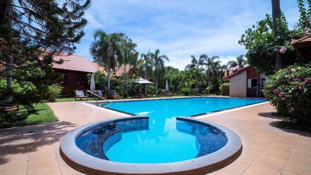 a swimming pool in the backyard of a house at Bangsaray Village Resort in Ban Nong Chap Tao