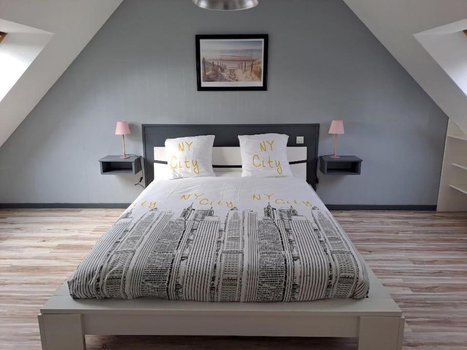 a bedroom with a large bed with a newspaper at Gîte Les Pareurs in La Ferté-Macé