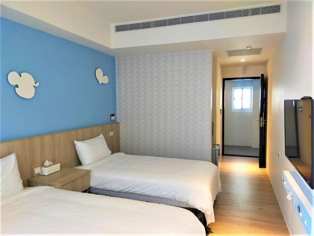een hotelkamer met 2 bedden en een televisie bij 棉花雲文旅民宿B&B in Ch'ao-yang
