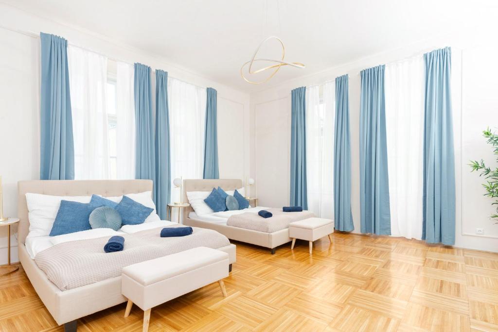 uma sala de estar com duas camas e cortinas azuis em Spacious and Near Metro, Perfect for Groups of 14 em Viena