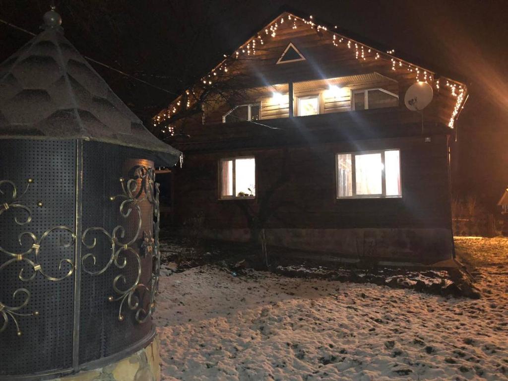 a house with lights on top of it in the snow at Садиба Криниченька in Yaremche