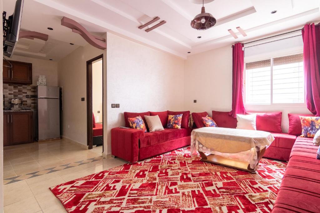 sala de estar con sofá rojo y alfombra en App GH7, en Agadir