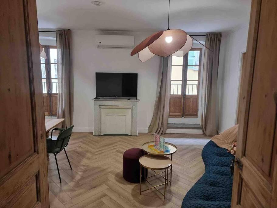 uma sala de estar com um sofá azul e uma televisão em Appartement au cœur de la ville em Corte