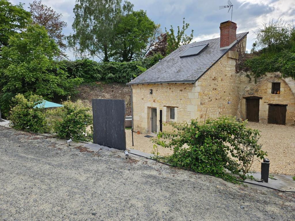 uma velha casa de tijolos na beira de uma estrada em Maison 2-3 pers semi-troglodyte Angers-Saumur em Louresse-Rochemenier