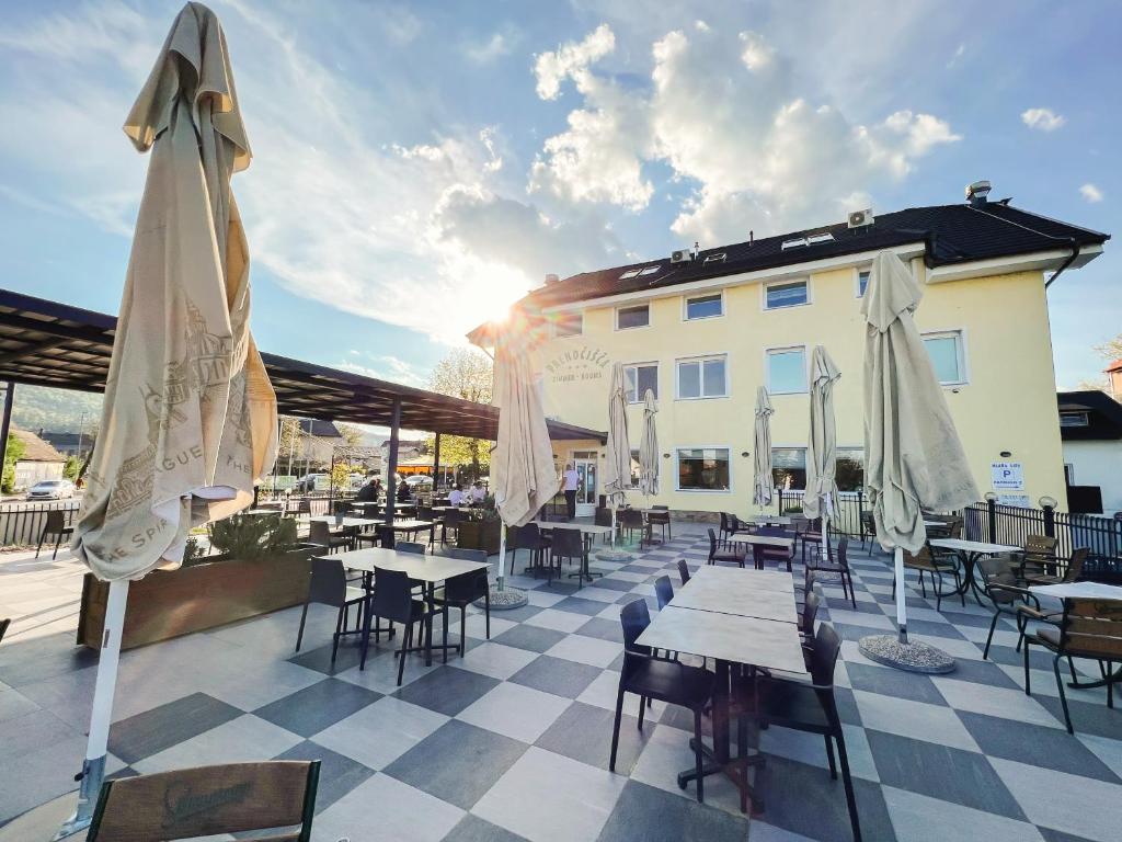 a patio with tables and umbrellas in front of a building at Guest House Mlada lipa in Maribor