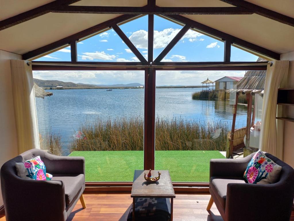 een kamer met een groot raam met uitzicht op een meer bij Uros Aruma-Uro on Uros Floating Islands in Puno