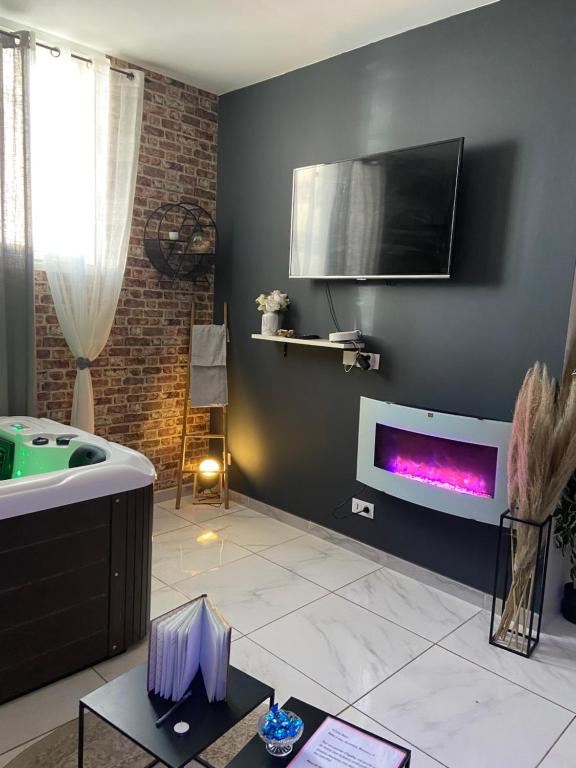 Elle comprend un salon avec une baignoire et une télévision murale. dans l'établissement Nuit privée, à Cannes