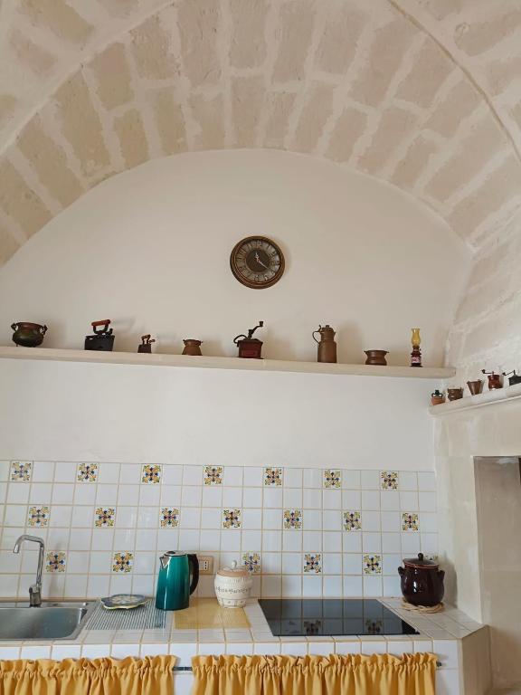 kuchnia ze zlewem i zegarem na półce w obiekcie Casa vacanze Chiarodiluna w mieście Giurdignano