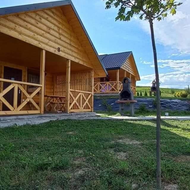 a large wooden house with a tree in front of it at Bieszczadzkie domki z widokiem 793-903-243 in Bukowiec