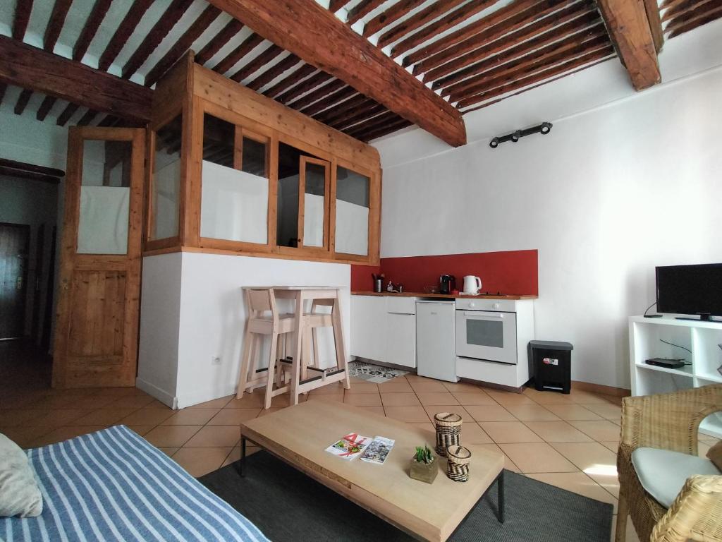 salon z łóżkiem i stołem oraz kuchnia w obiekcie CORDELIERS MAIRIE w Aix-en-Provence