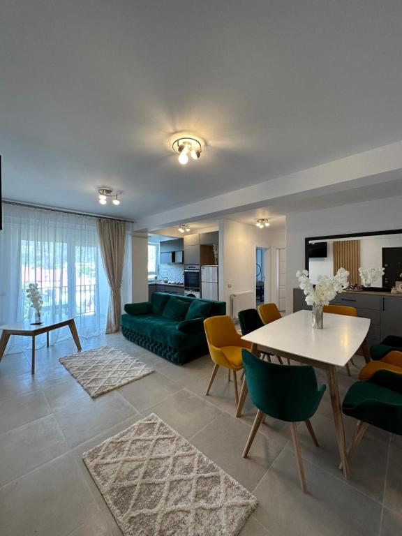 uma sala de estar com um sofá verde e uma mesa em Apartamente Ariniș em Gura Humorului