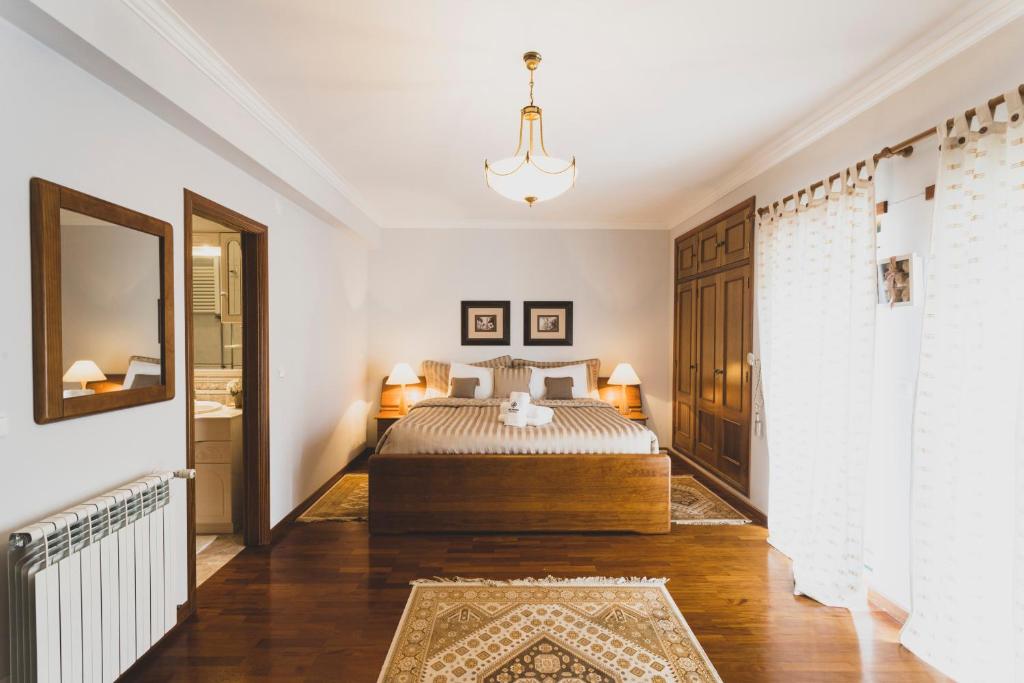 1 dormitorio con cama y lámpara de araña en Best Houses 81 - Sea La Vie, en Atouguia da Baleia