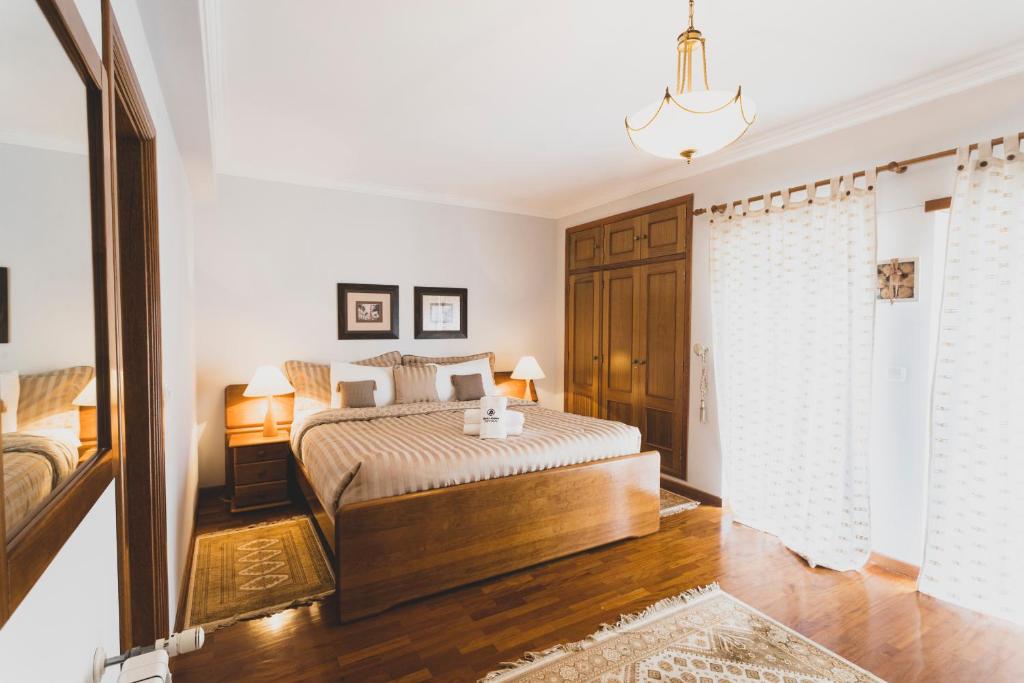 a bedroom with a king sized bed and a mirror at Best Houses 81 - Sea La Vie in Atouguia da Baleia