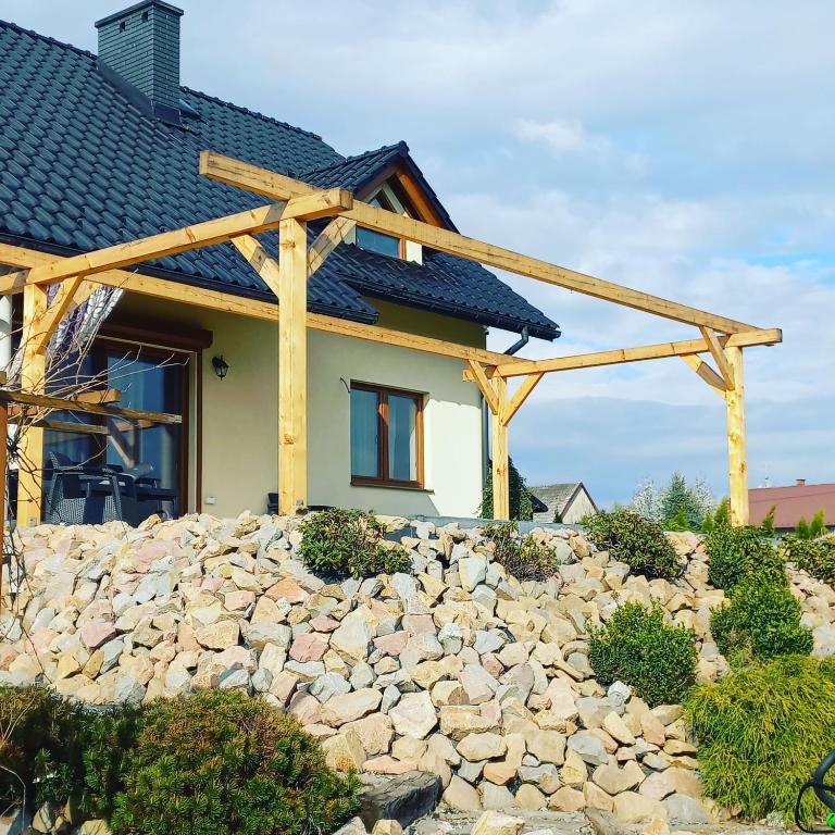 a house with a stone wall in front of a house at WillaTwins in Tomice