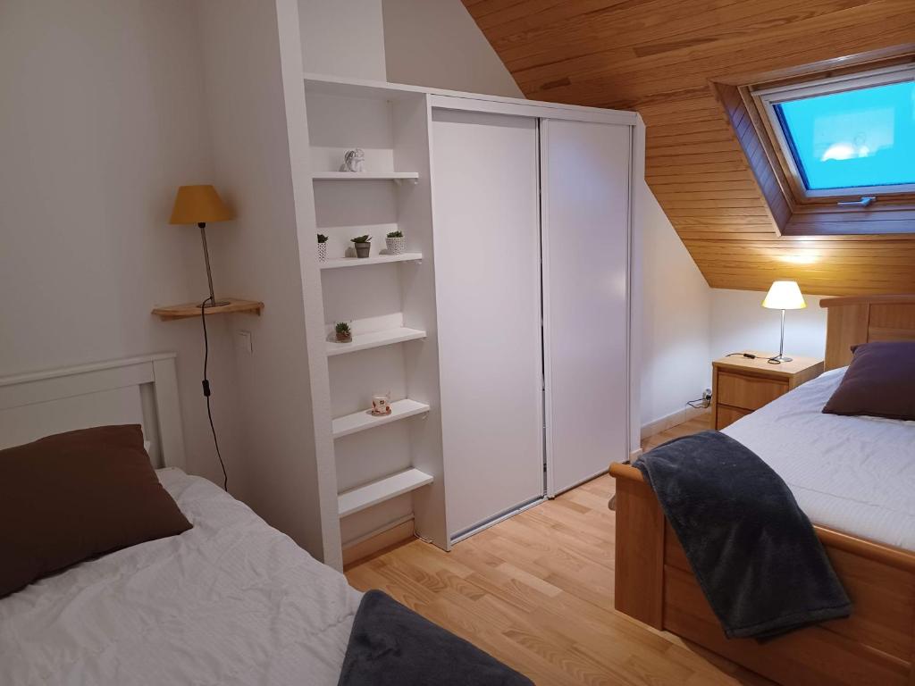 um pequeno quarto com 2 camas e uma janela em Appartement duplex classé 4 étoiles plein centre village em Saint-Lary-Soulan