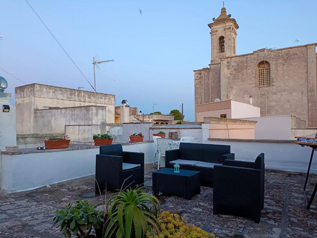patio z krzesłami i stołami na dachu budynku w obiekcie Casa vacanze Chiarodiluna w mieście Giurdignano