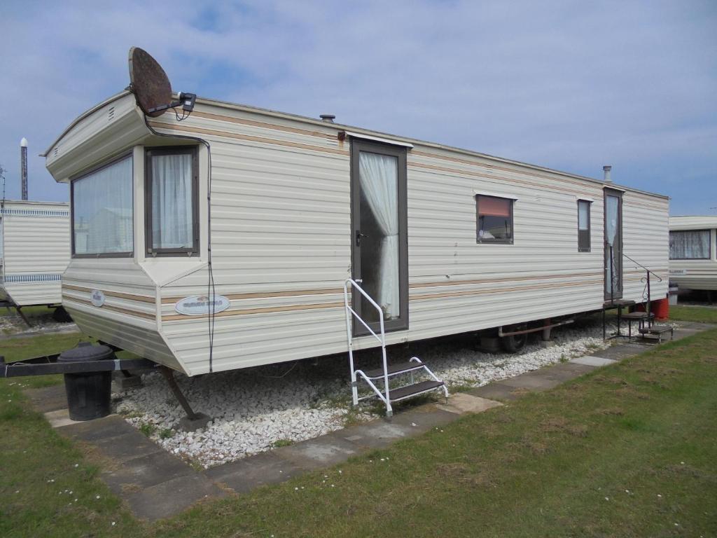 an old white trailer parked in a yard at 7 Berth on Coral Beach Granada II in Ingoldmells