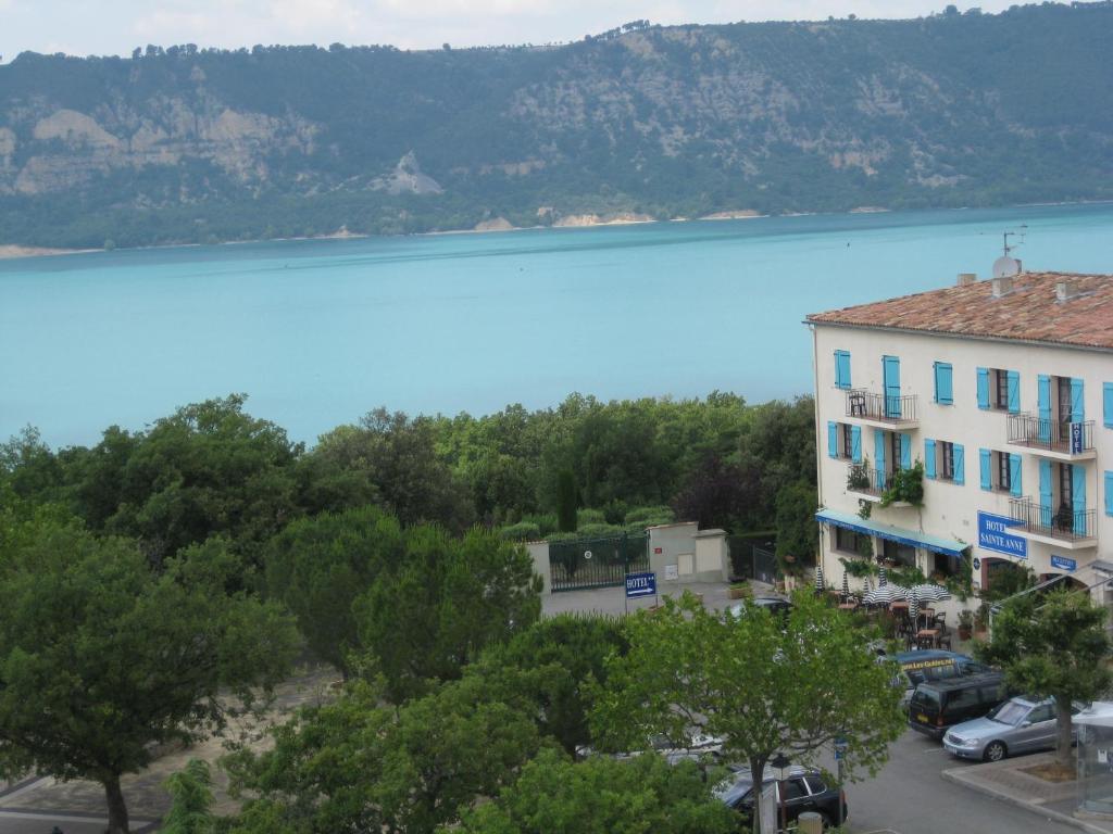 Elle offre une vue sur un bâtiment et un lac. dans l'établissement Hôtel Sainte Anne, aux Salles-sur-Verdon