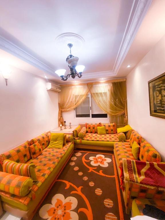 een woonkamer met banken en een tapijt bij residence al farah sala aljadida in Sale