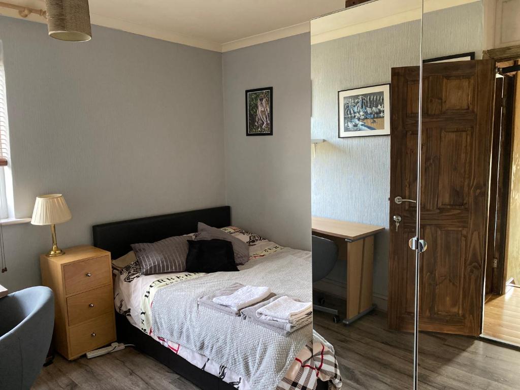 a bedroom with a bed and a glass shower at Cosy room in cul de sac location’s home in Dagenham