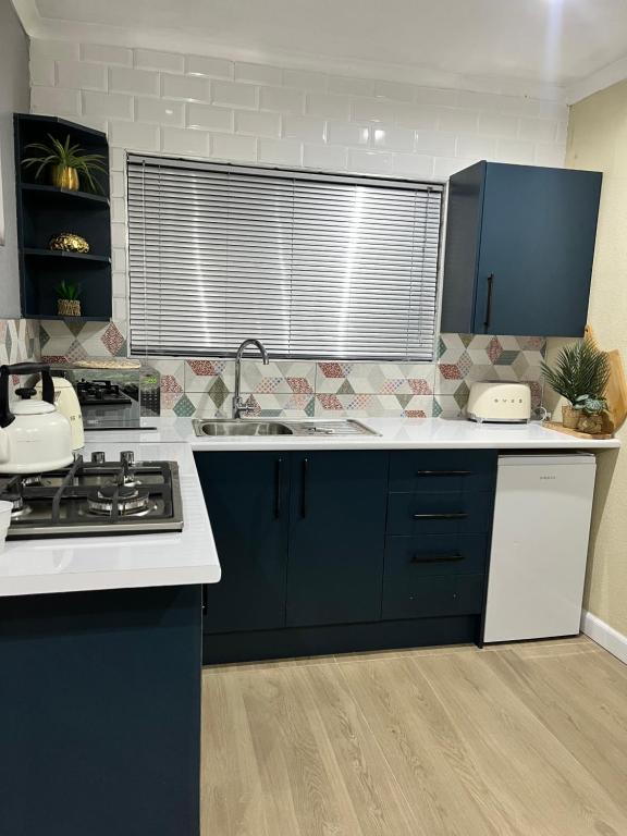 a kitchen with blue cabinets and a white counter top at Modern studio apartments in Secunda