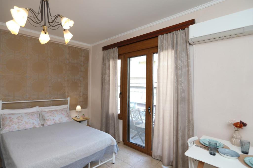 1 dormitorio con 1 cama y ventana con balcón en Niki's apartement en Kavala