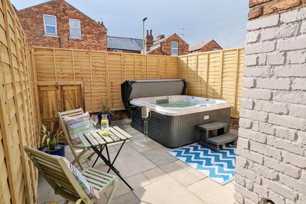 een kleine achtertuin met een hot tub en stoelen bij Seaside Escapes - with relaxing hot tub! in Scarborough