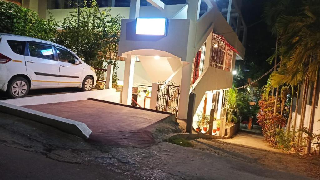 ein weißes Auto, das nachts vor einem Haus parkt in der Unterkunft The Lotus Home in Port Blair