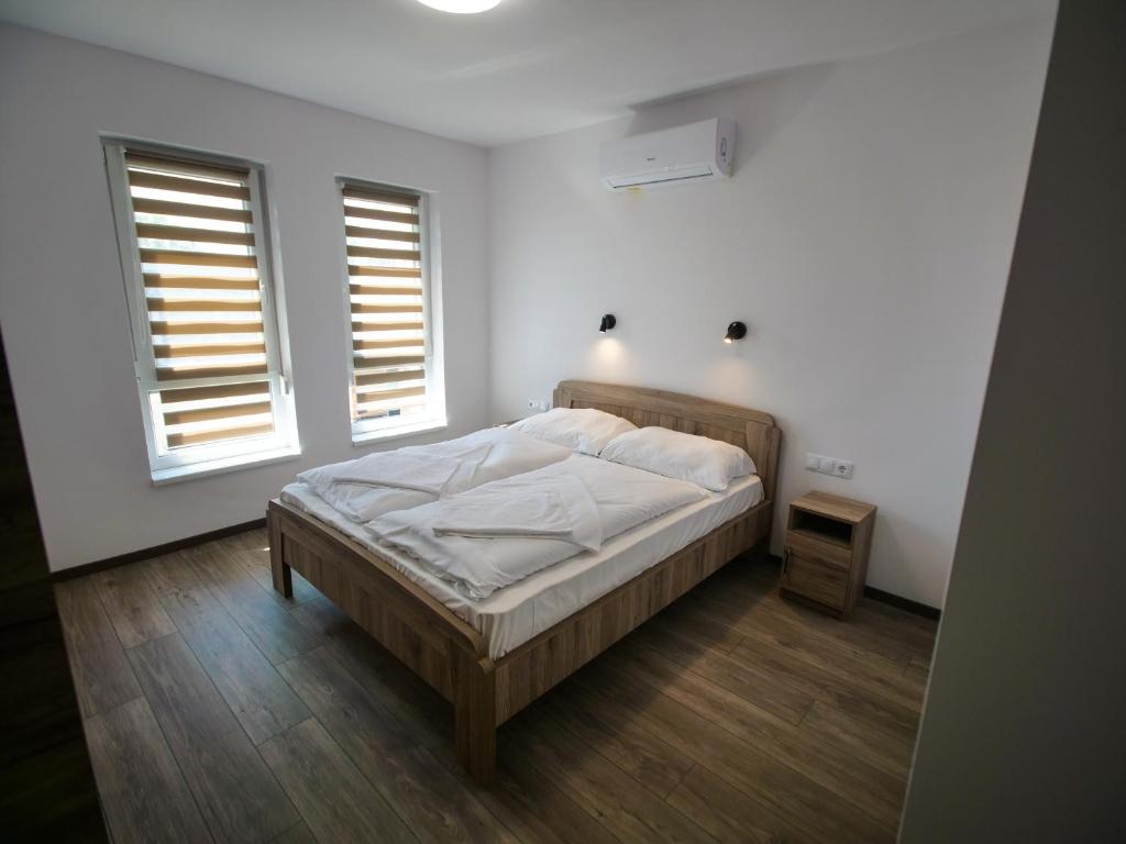 バラトンフェニヴェシュにあるZea Apartmanházの白いベッドルーム(ベッド1台、窓2つ付)