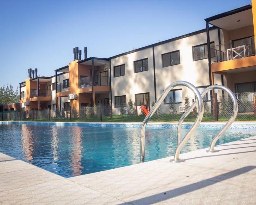 una piscina frente a un edificio en Hermoso departamento con vistas al verde y pileta! en Pilar