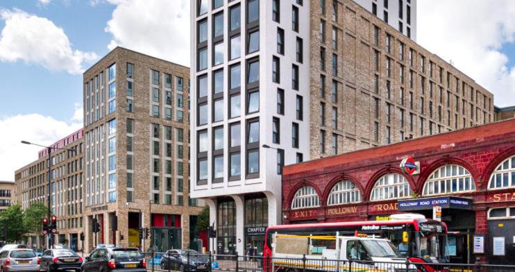 Holloway Studio في لندن: شارع المدينة مزدحم بالمباني الطويلة والسيارات