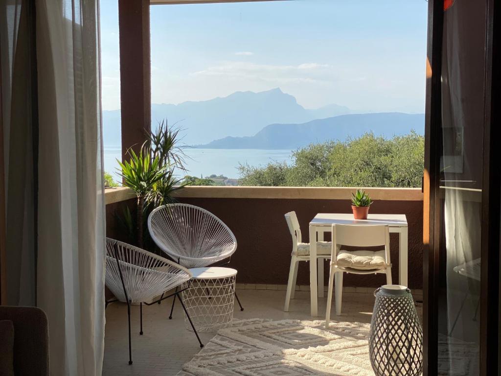 a balcony with a table and chairs and a view at Boutiqueloft Vista in Bardolino