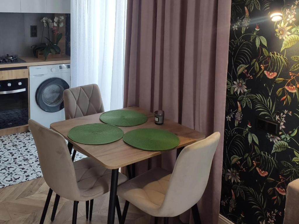 BotaNika في كريمنشوك: طاولة طعام وكراسي عليها لوحات خضراء