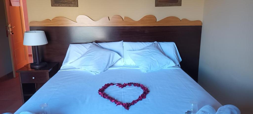 un corazón hecho de almohadas en una cama en Hotel Restaurante Comendador Añon de Moncayo, en Añón