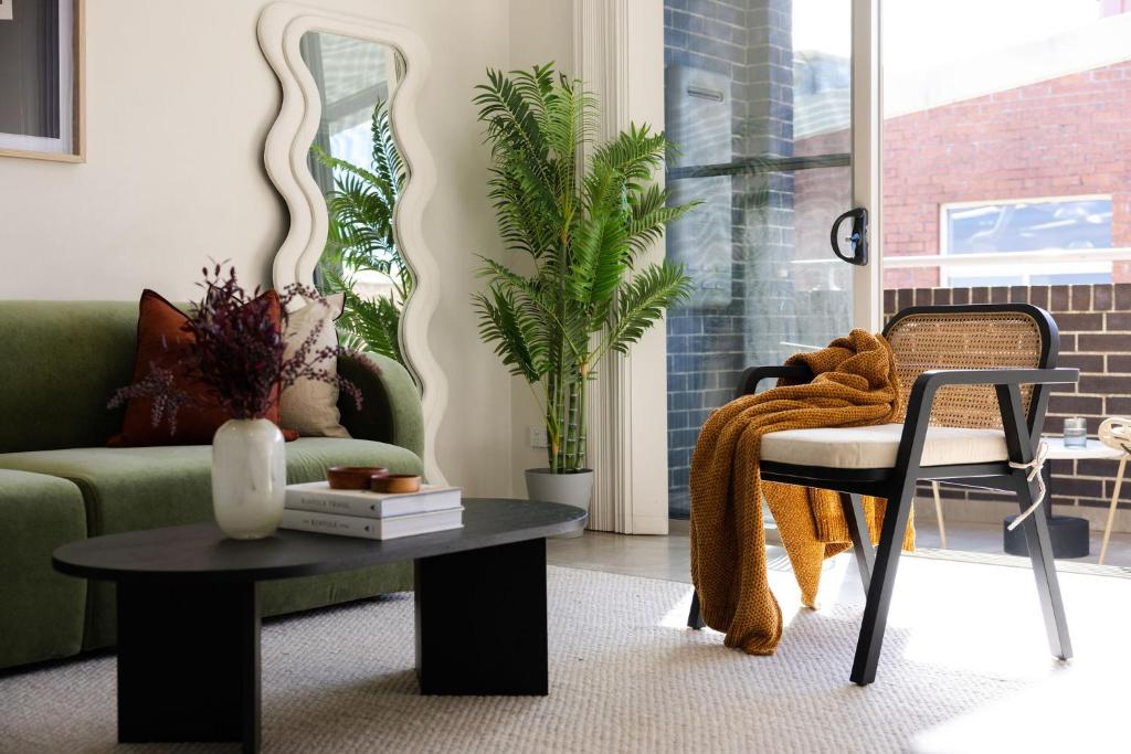 uma sala de estar com um sofá e uma mesa em Kahlo Alexandria - Stylish 2 bdrm Walk to Train em Sydney