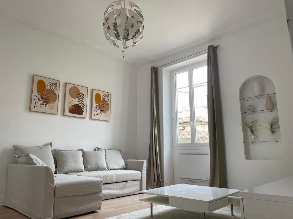 a living room with a couch and a table at Appartemment Nimes Arènes in Nîmes