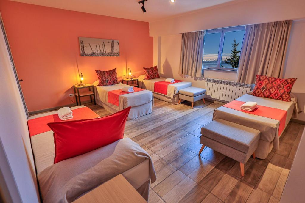 a hotel room with two beds and a couch at Hotel Tierra Gaucha in San Carlos de Bariloche