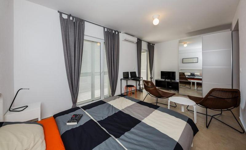 Studio Apartment Stela في فربوسكا: غرفة نوم مع سرير وغرفة معيشة