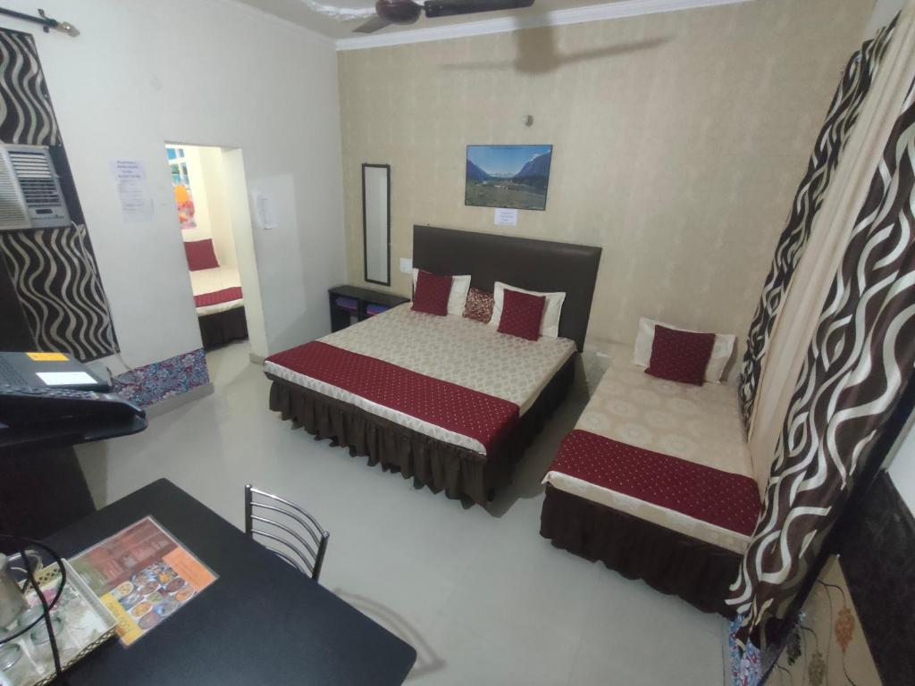a bedroom with two beds and a table and a desk at New Chandigarh Holiday Home in Chandīgarh