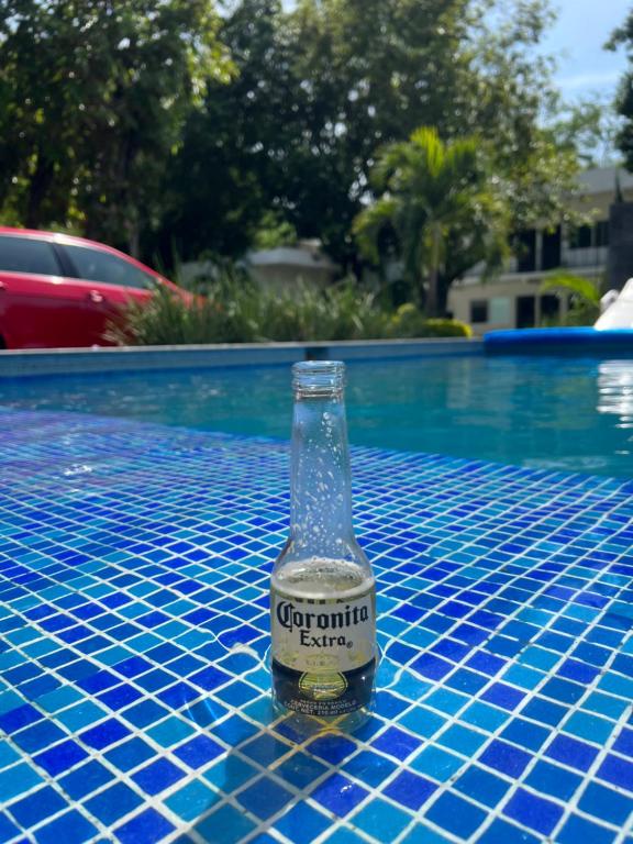 een fles corona bier zittend op een tafel naast een zwembad bij Hotel Boutique Luciérnaga in Chiconcuac
