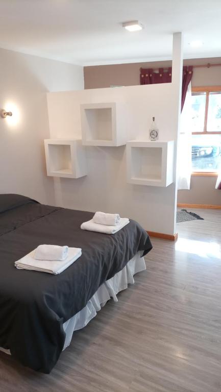 1 dormitorio con 1 cama con 2 toallas en LODELASTRO B en El Chaltén