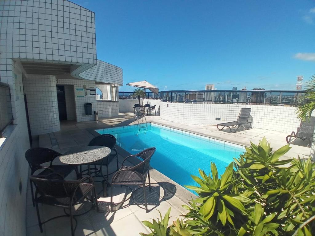 a patio with a table and chairs next to a swimming pool at Apto 2/4 Centro Recife in Recife