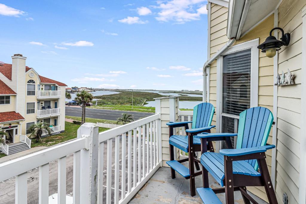 2 sillas azules en un balcón con vistas al océano en Casa Del Sol, en Padre Island