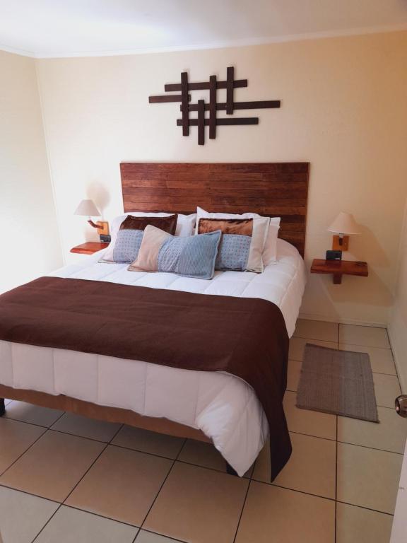 a bedroom with a large bed with a wooden headboard at Cabañas Refugio Nativo in Santa Cruz