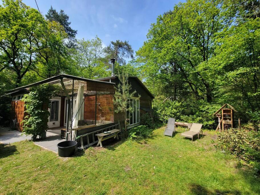 een kleine hut midden in een tuin bij Bungalow in het bos in Nunspeet