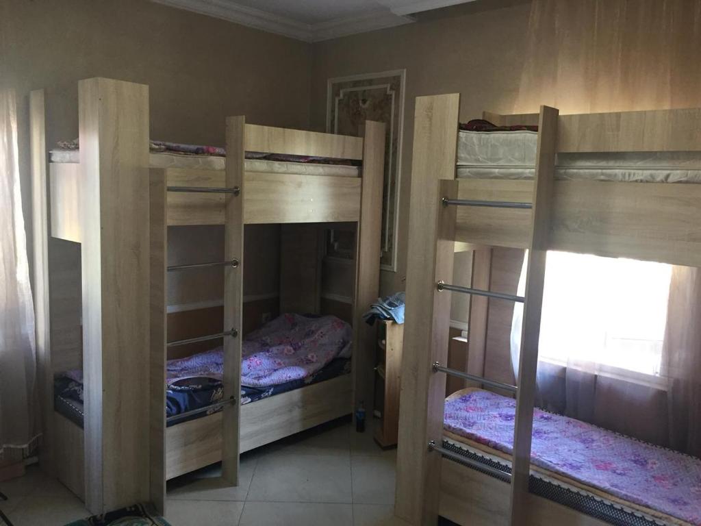 Hostel A99 في أستانا: غرفة مع ثلاثة أسرة بطابقين في غرفة