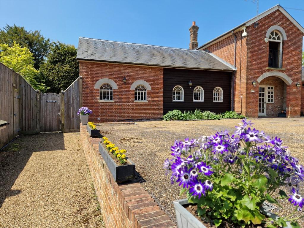a brick church with flowers in front of it at The Coach House in Hawkhurst