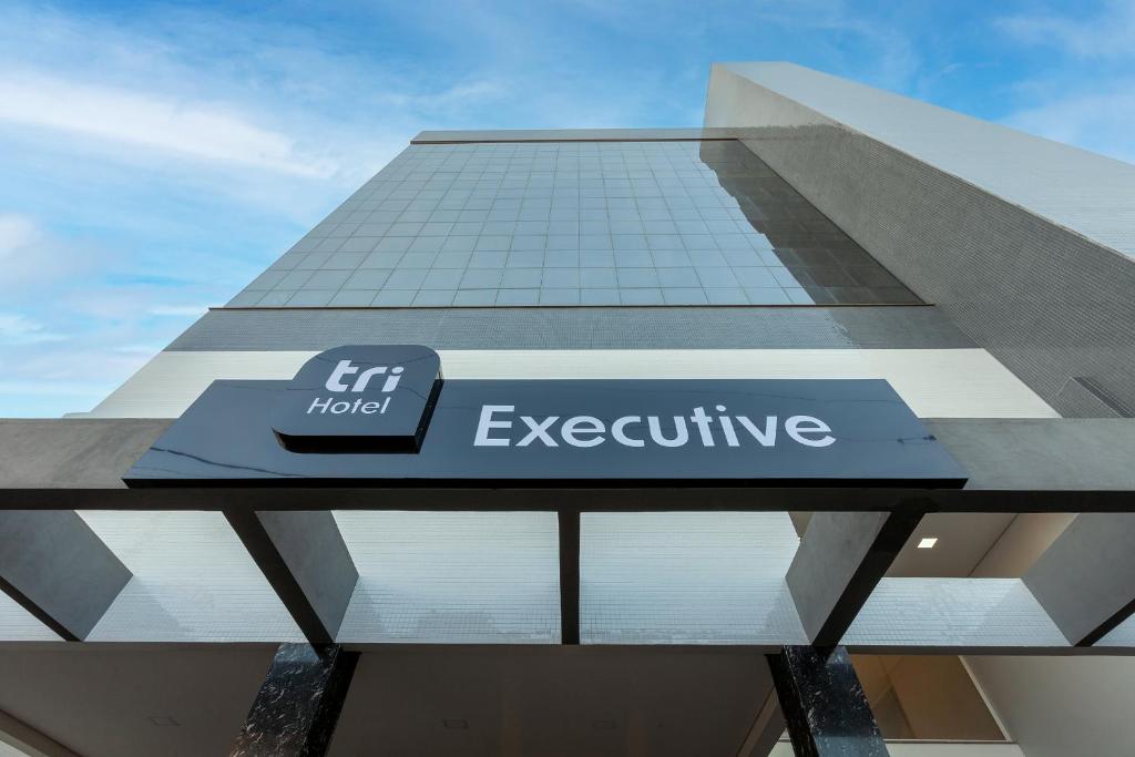 um edifício com uma placa que diz que é um hotel executivo em Tri Hotel Executive Osório em Osório